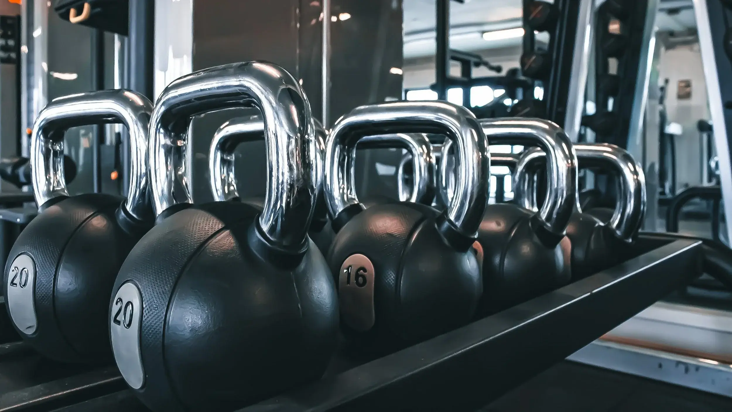 A rack of kettlebells on the gym floor